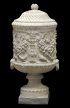 Cinerary vase with decorative handles and the body carved with candelabra(?) and garlands. 