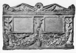 A Roman double funerary urn (cinerarium) and lid, carved with garlands held up by bukrania and dolphins at the lower front corners. 