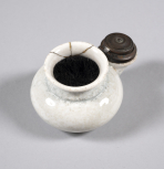 A white china ink pot with attached inkwell with brass lid