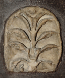 A Roman antefix with stylised honeysuckle palmette-plant within a fillet border.