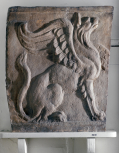 An end panel from a Roman sarcophagus carved wtih a Griffin in relief
